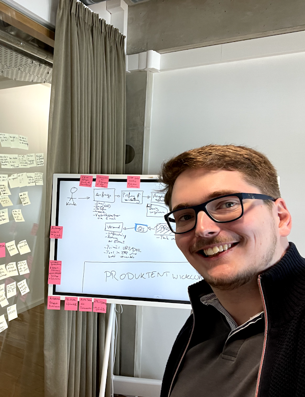 Ferdinand Biere, the CEO, standing in front of a whiteboard surrounded by post it notes at one of the workshops he did for his clients.